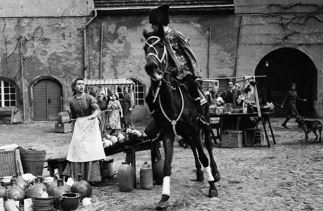 König Drosselbart (1954): Die als Husar verkleidete Titelfigur (Ottokar Runze) zerschlägt das Geschirr von Prinzessin Christine (Gisela Fritsch) / © Studiocanal